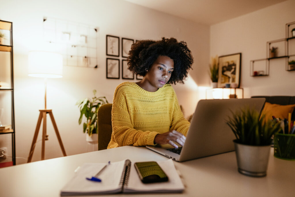 Jovem mulher negra na frente do computador que estar a estudar online.